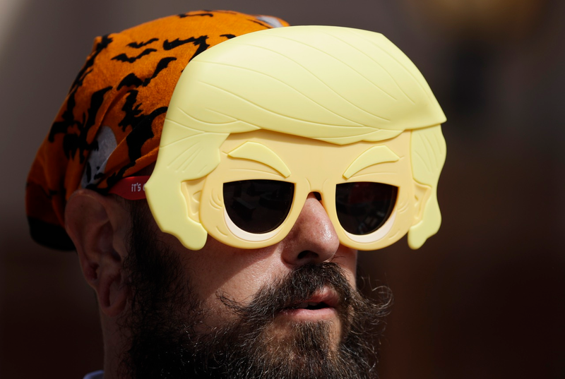A man wears a Trump mask before a rally on Oct. 3, 2016, in Pueblo, Colo. (AP Photo/John Locher)